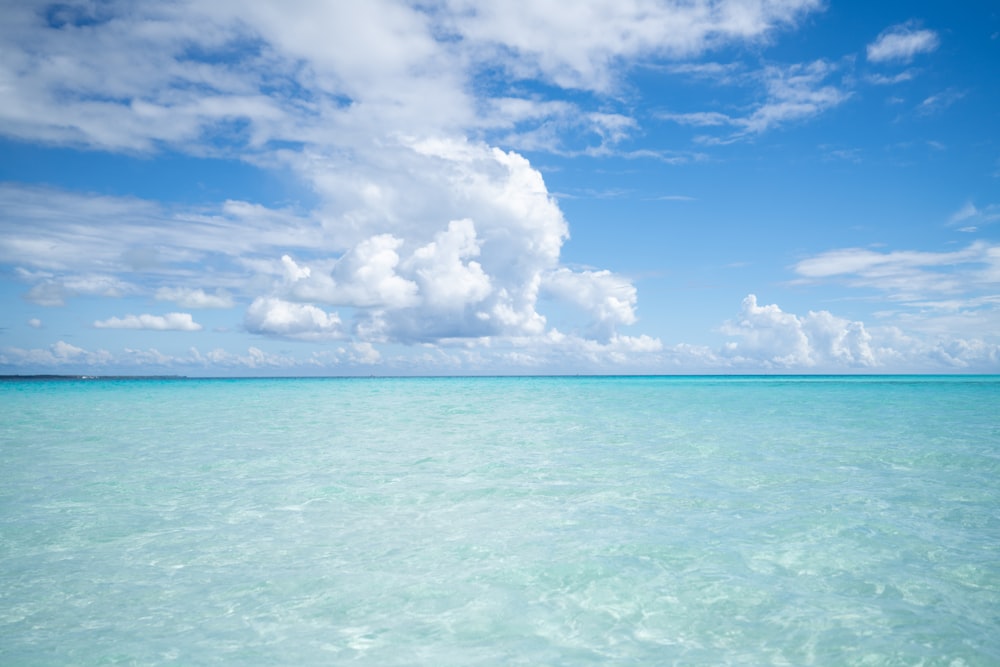 a large body of water sitting under a cloudy blue sky