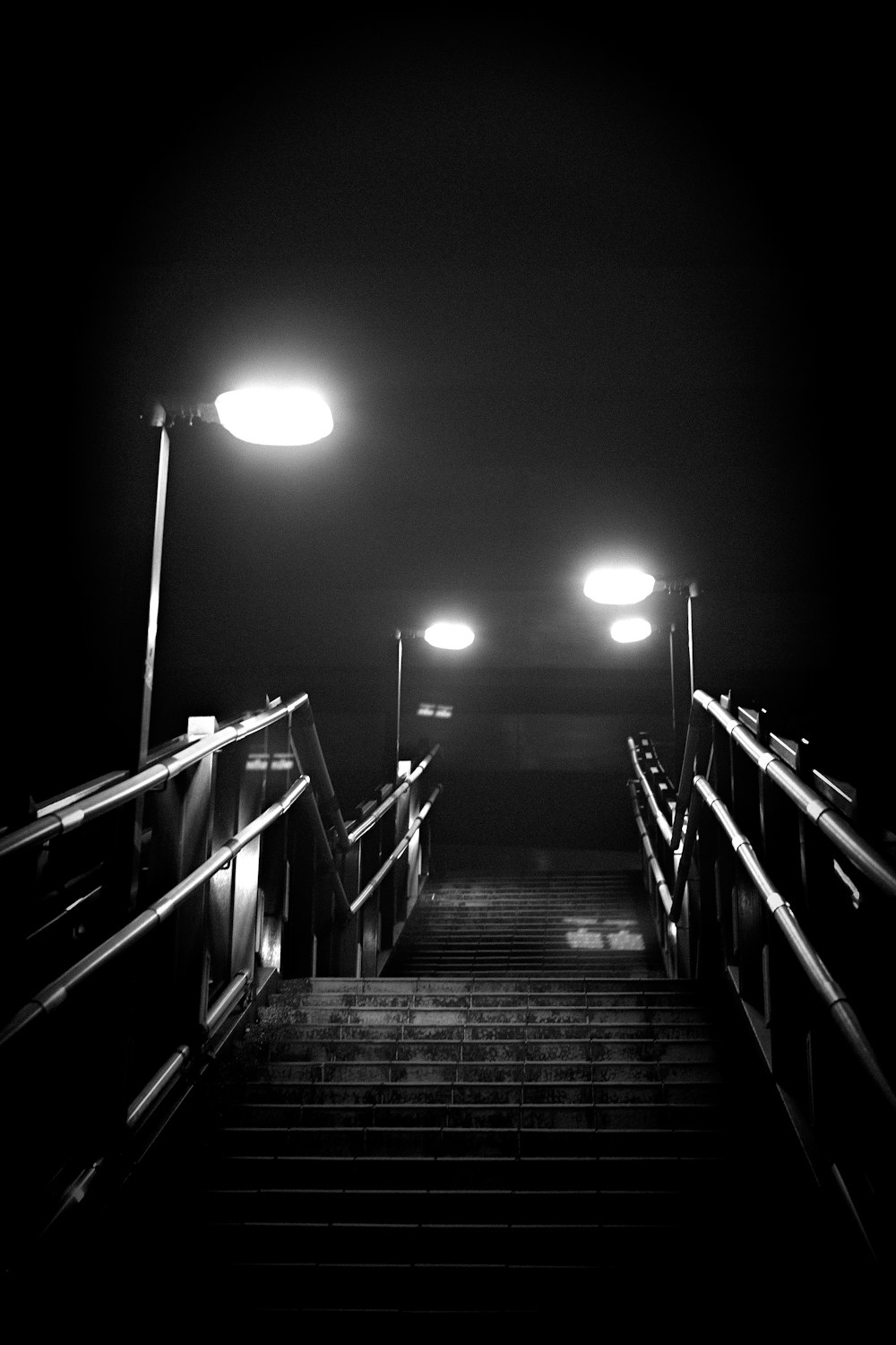 a black and white photo of a stairway at night