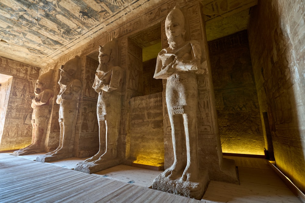 a group of statues in a room next to a wall