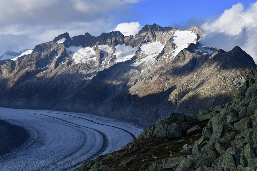 a mountain range with a glacier in the foreground