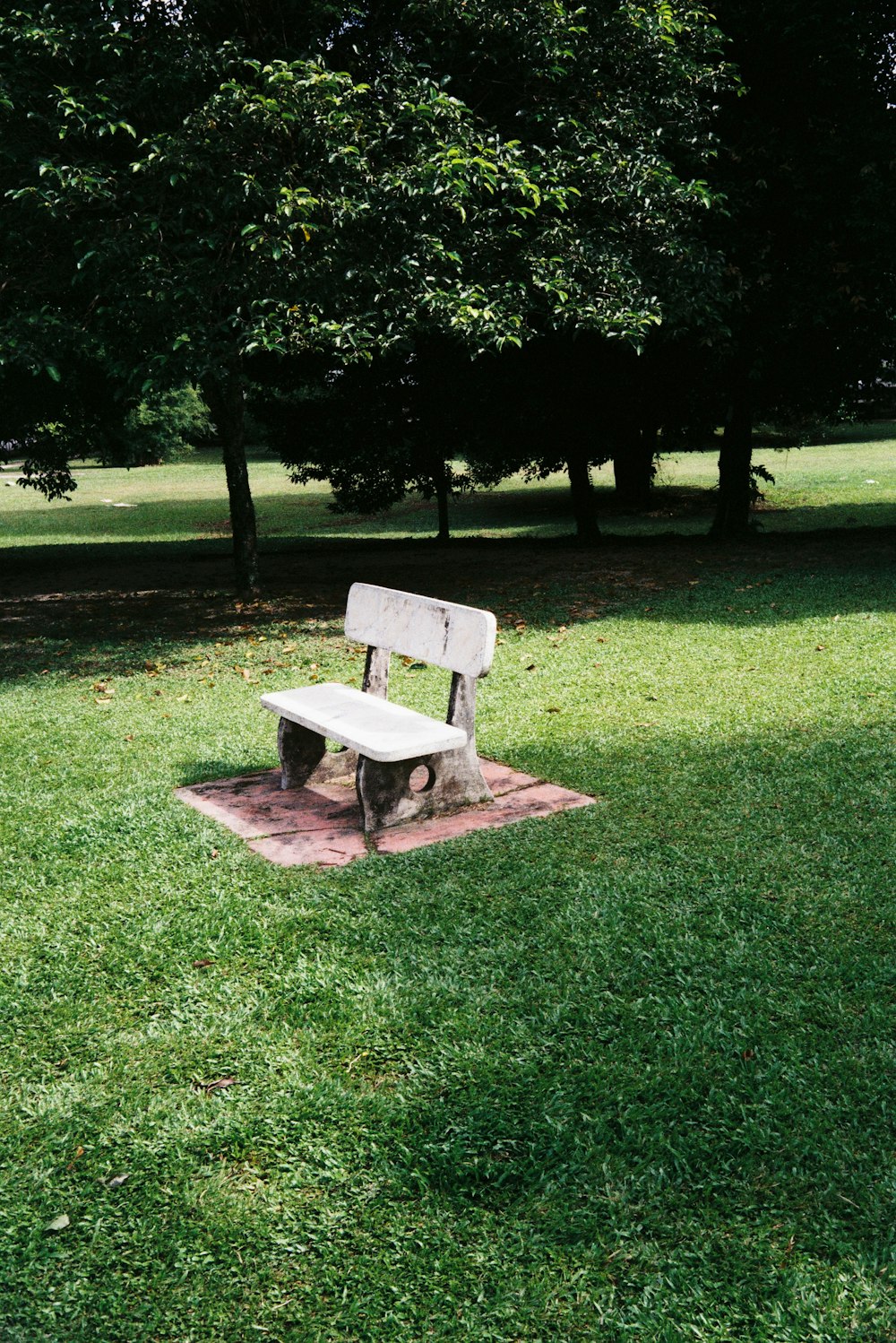 a park bench sitting on top of a green field