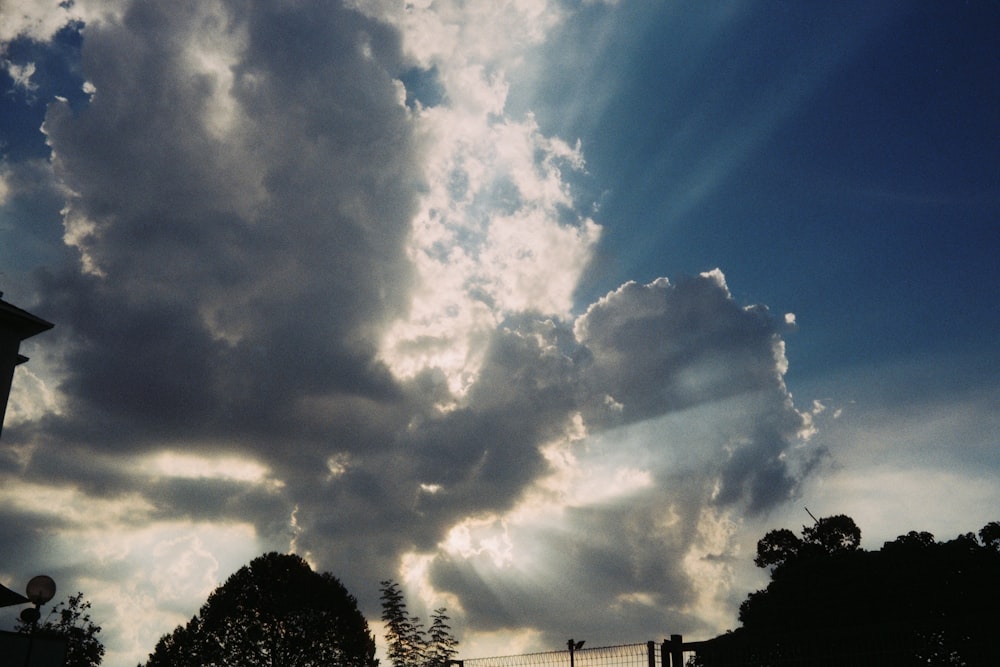 the sun shines through the clouds above a street