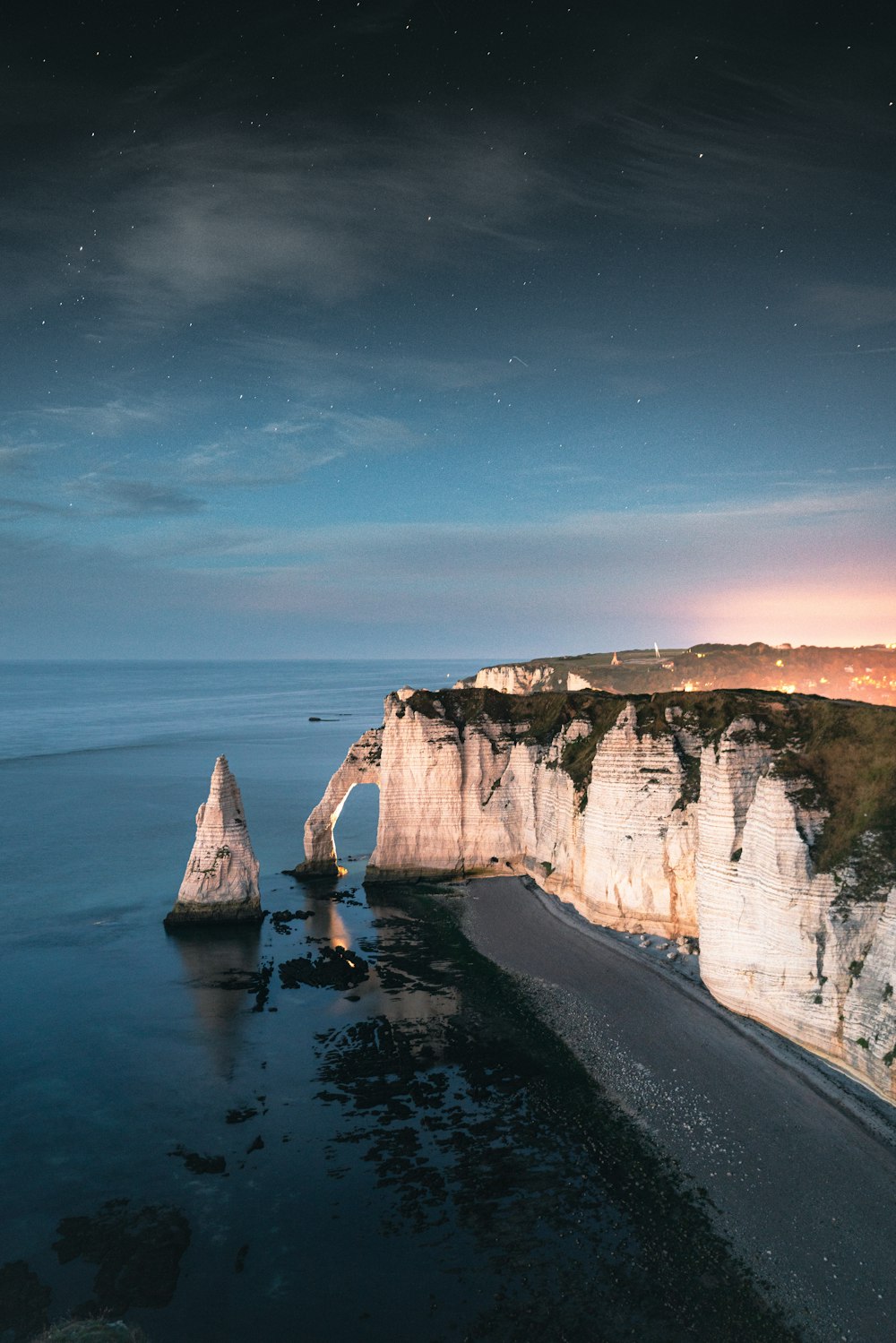 a view of a beach and cliffs at night