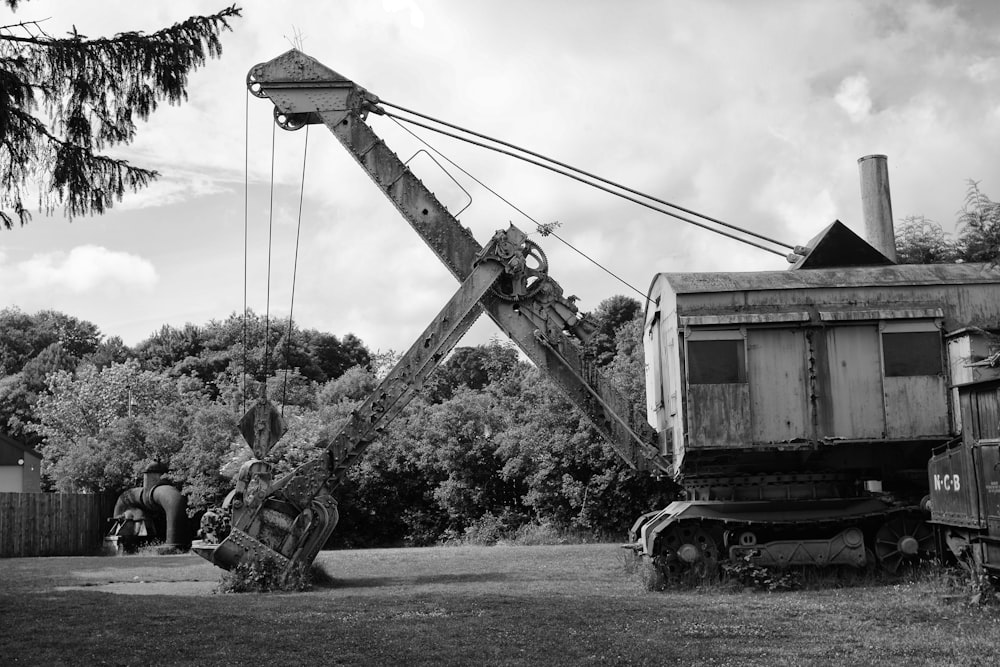 a black and white photo of a crane lifting a house