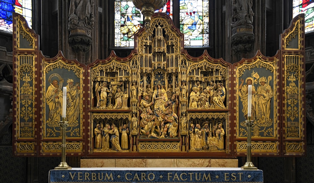 Ein sehr reich verzierter Altar in einer Kirche mit Buntglasfenstern