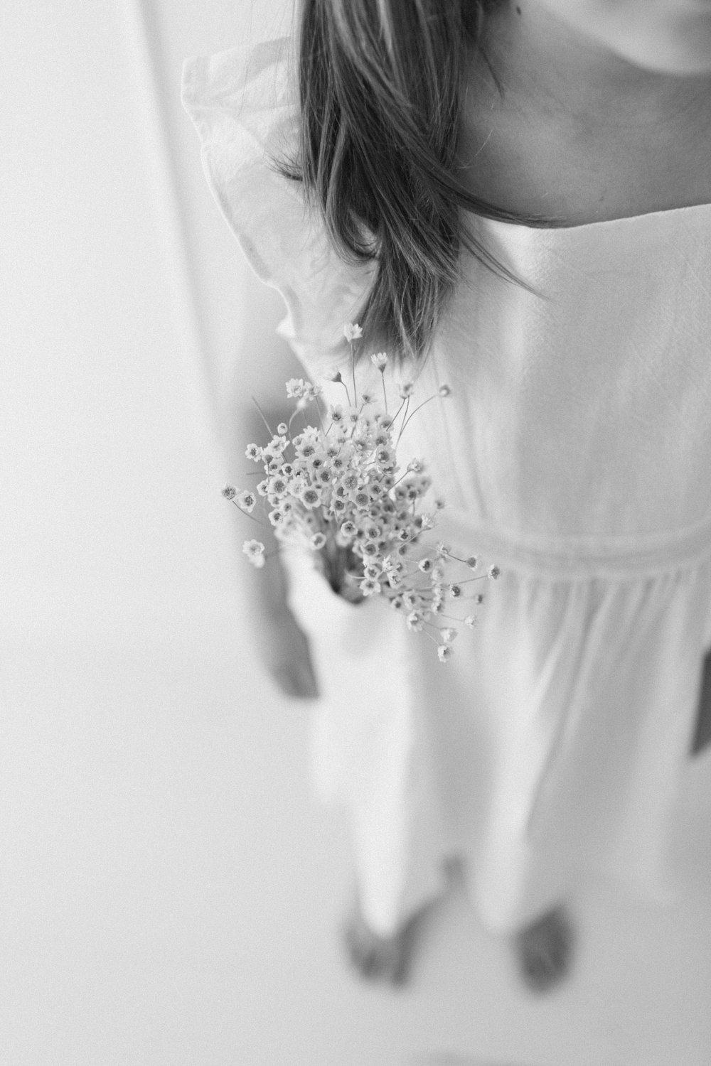 a woman in a white dress holding a bouquet of flowers