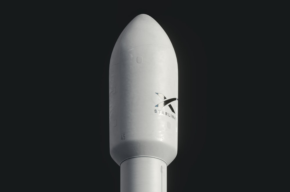 a close up of a white rocket on a black background