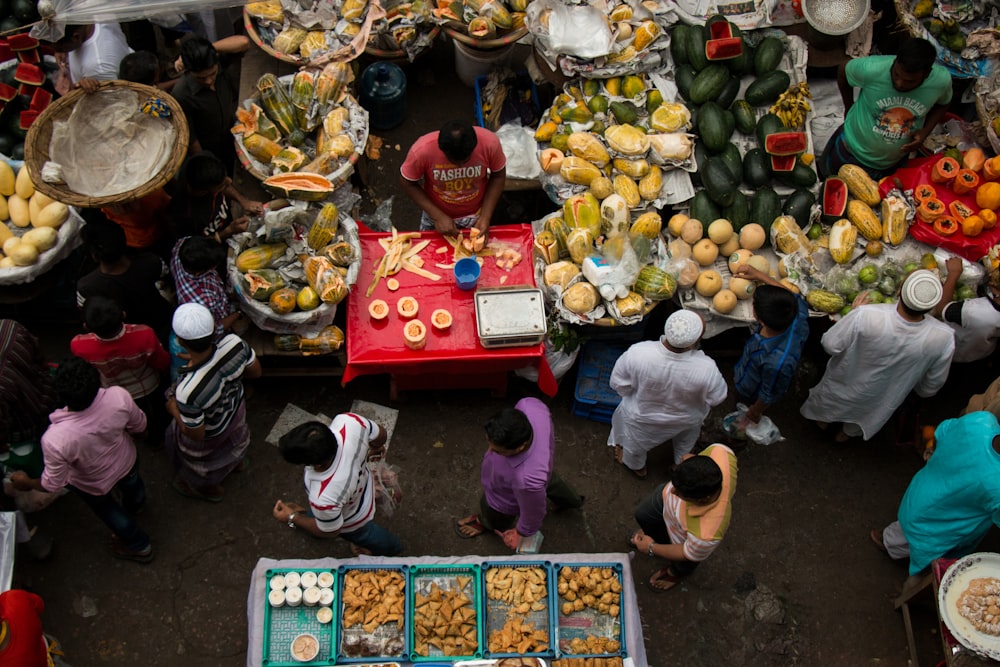 a group of people standing around a table filled with food