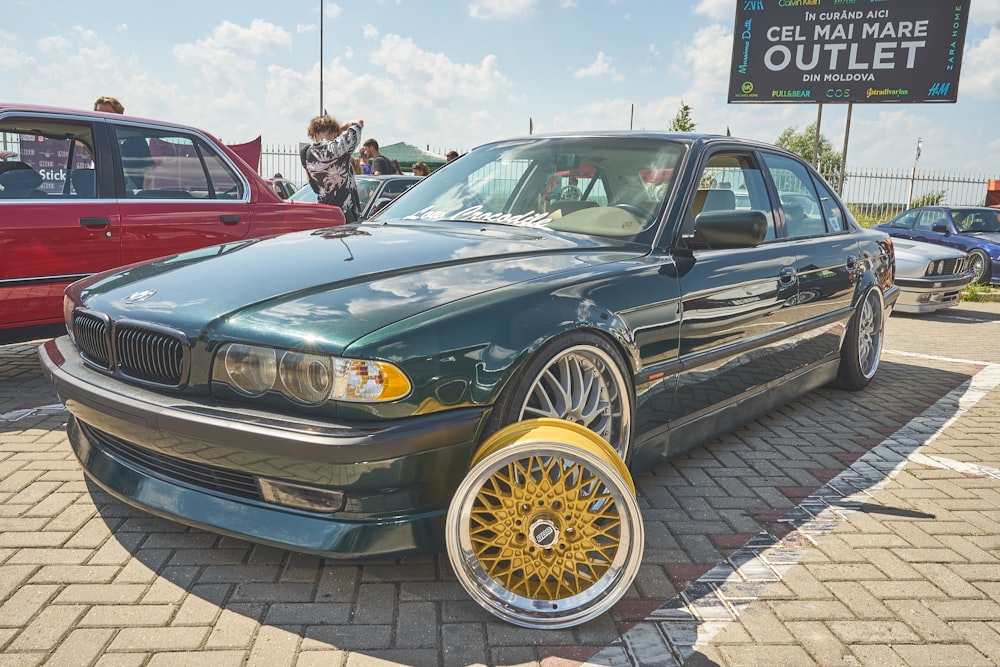 a green car parked in a parking lot next to other cars