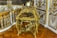 An ornate, antique desk with intricate gilt detailing and a small decorative clock on top. The surrounding decor includes lavish gold accents and detailed molding on the walls, reflecting a luxurious and historical style.