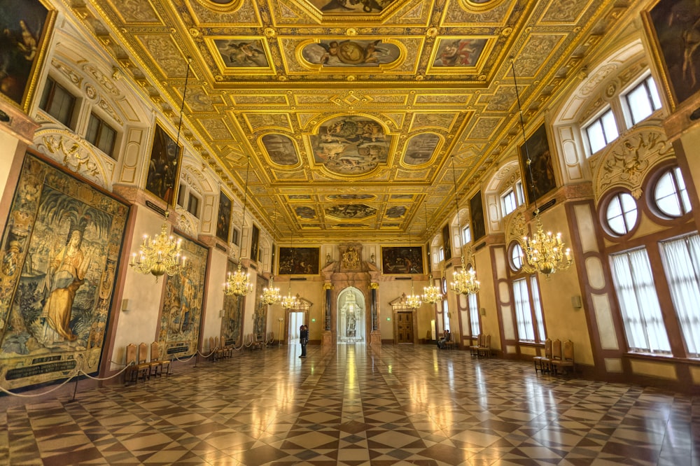 a large room with many paintings and chandeliers