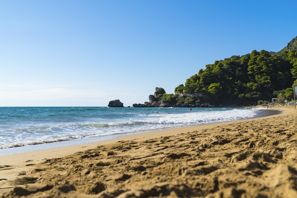 a sandy beach with waves coming in to shore