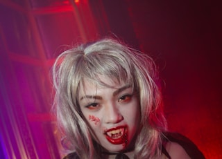 A young woman dressed as a vampire in a Halloween themed party