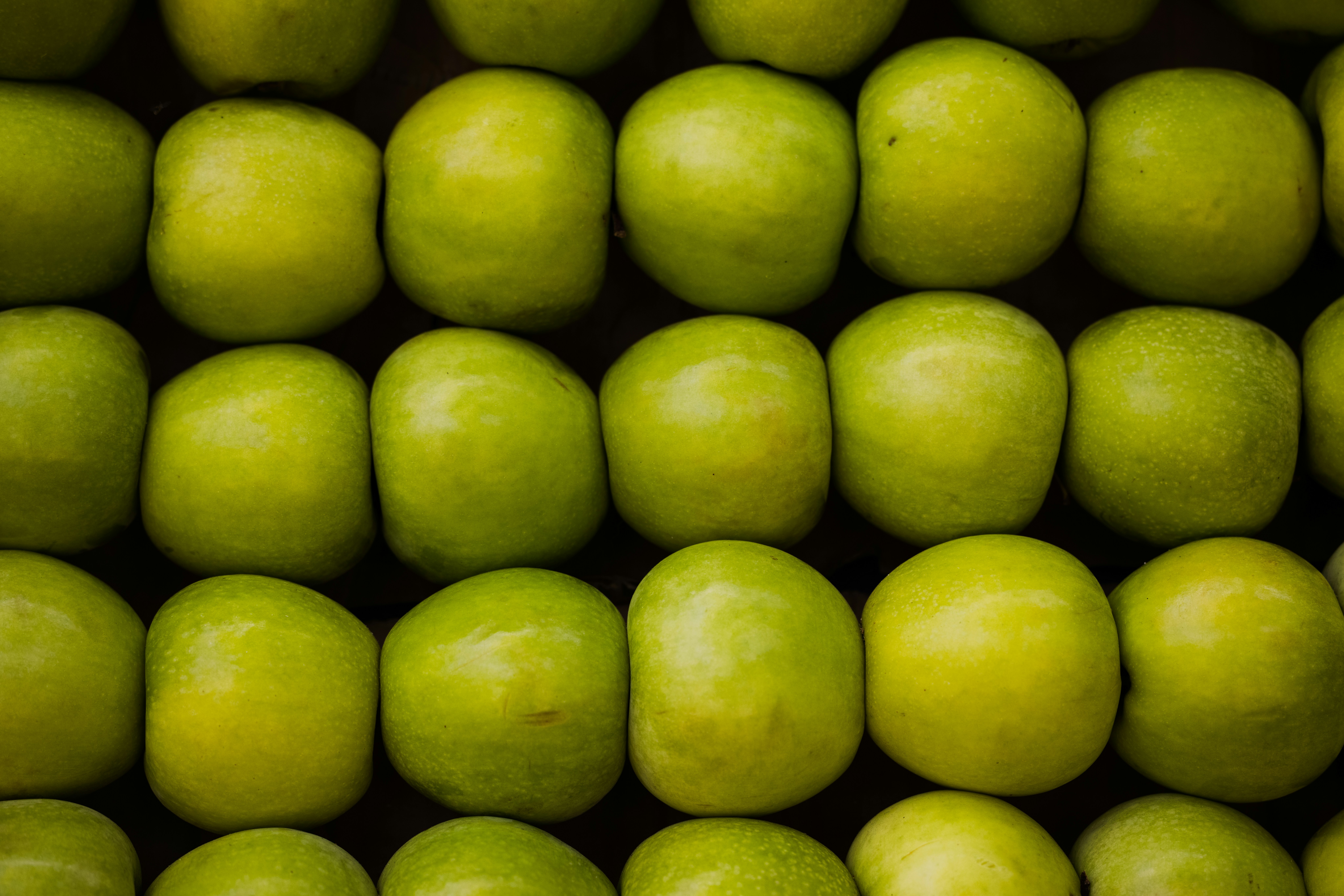 a group of green apples stacked on top of each other