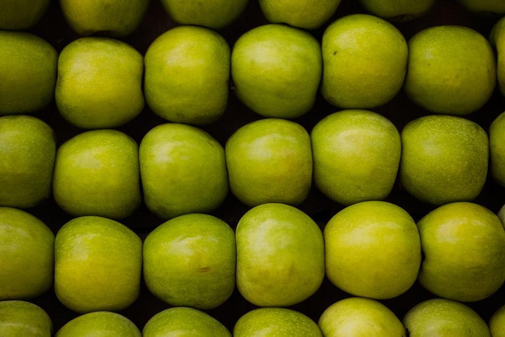 a group of green apples stacked on top of each other