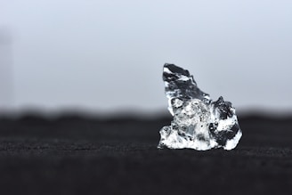 a piece of ice sitting on top of a black surface