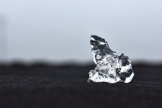 a piece of ice sitting on top of a black surface