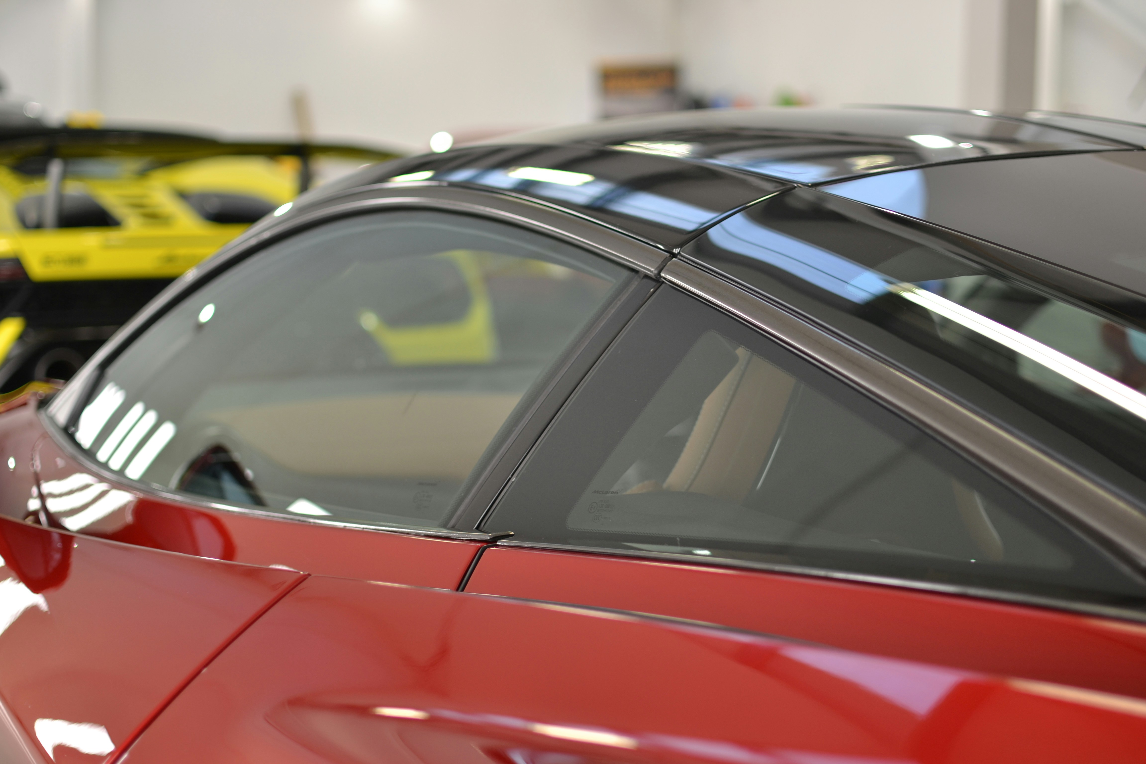 a red car parked in a garage next to other cars