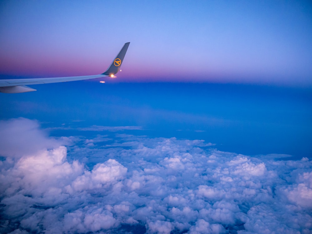 a view of the wing of an airplane above the clouds