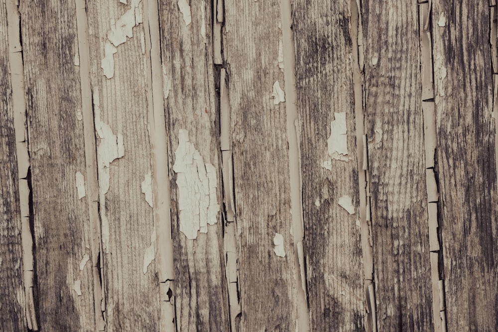 a close up of a wooden fence with peeling paint