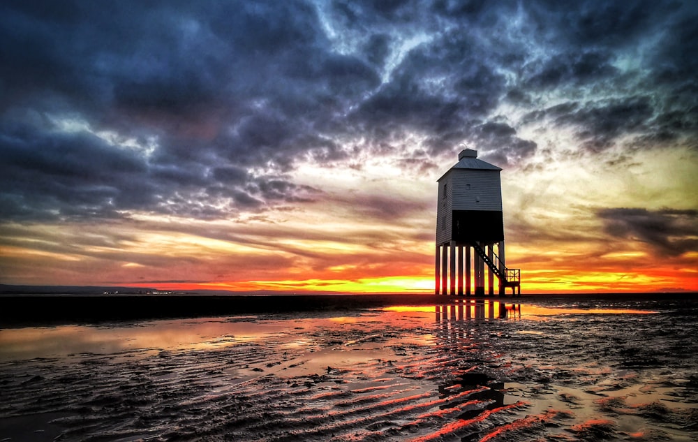 a lifeguard tower sitting on top of a sandy beach