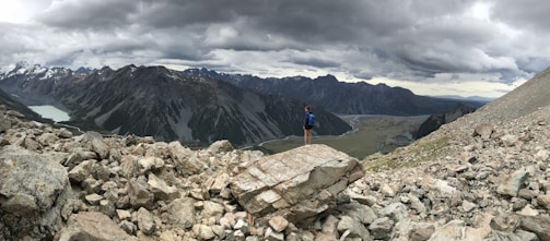 Hiker standing at a viewpoint overlooking Pico Duarte surrounded by clouds.