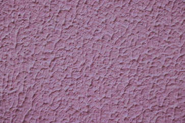 a close up of a pink stucco wall