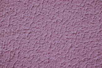 a close up of a pink stucco wall