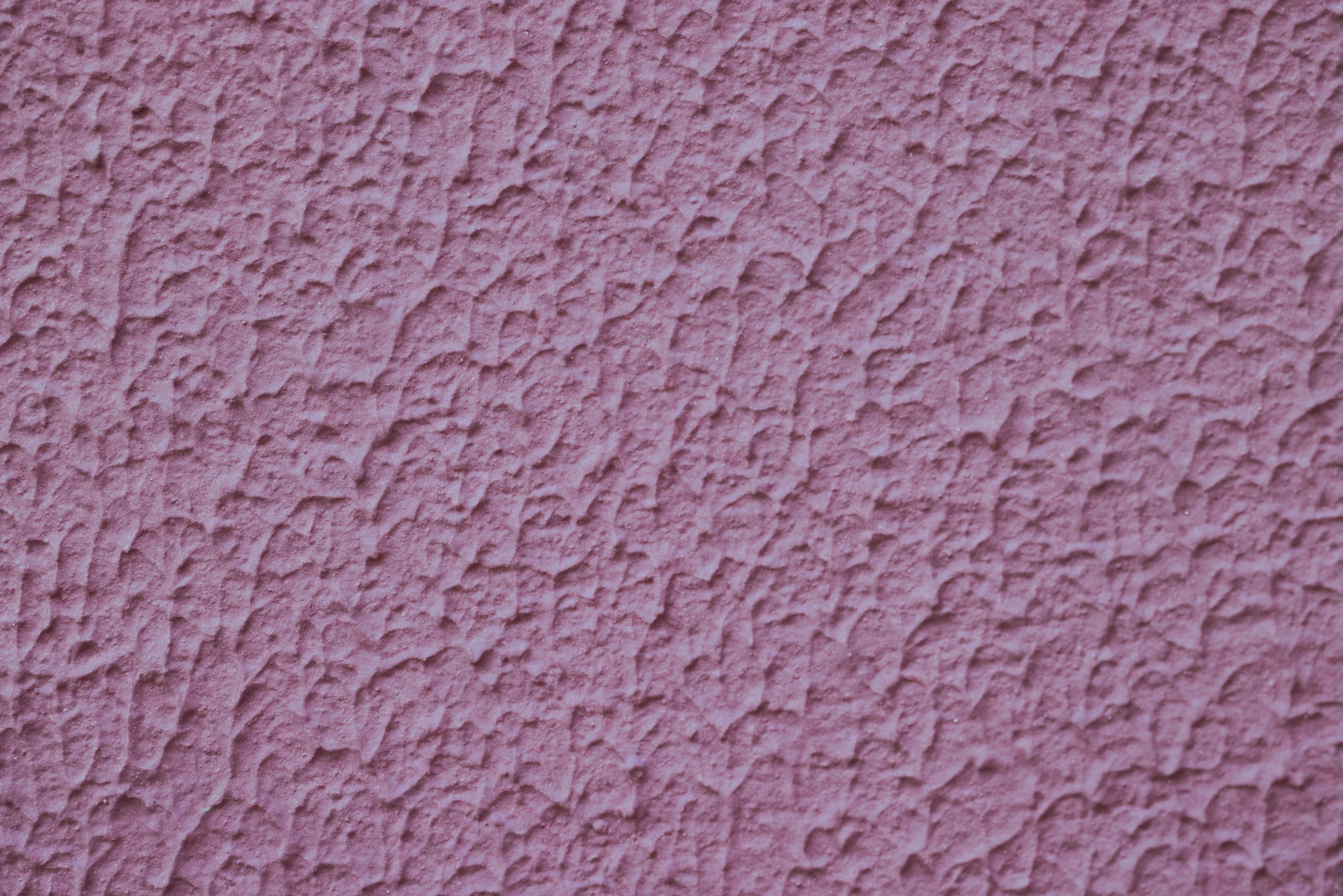 a close up of a pink stucco wall