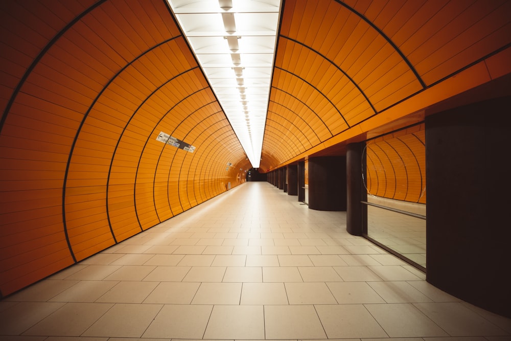 a long hallway with orange walls and tiled floors