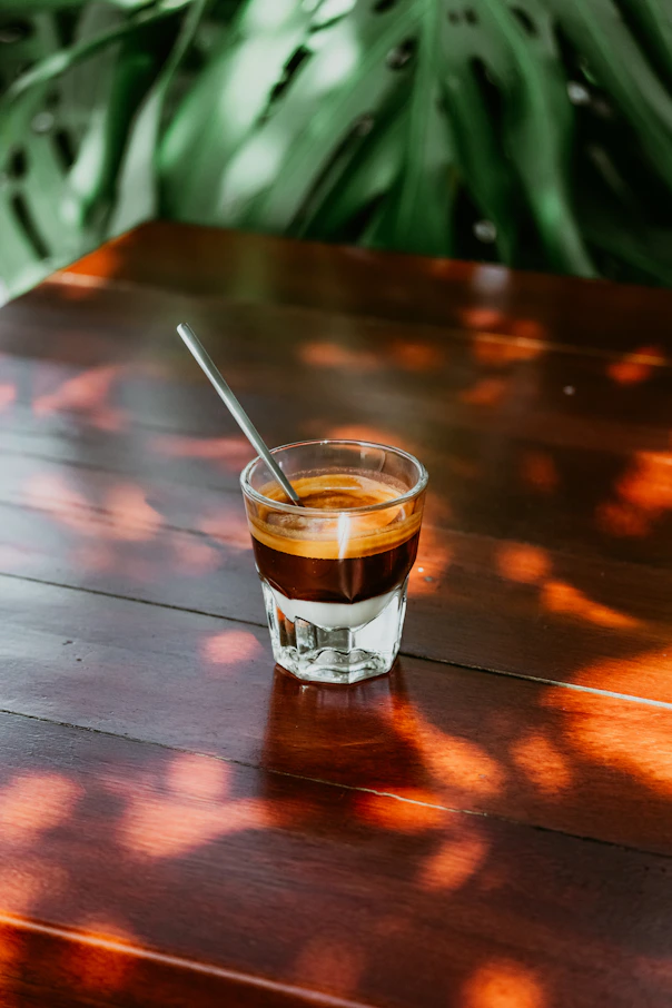 a cup of coffee sitting on top of a wooden table