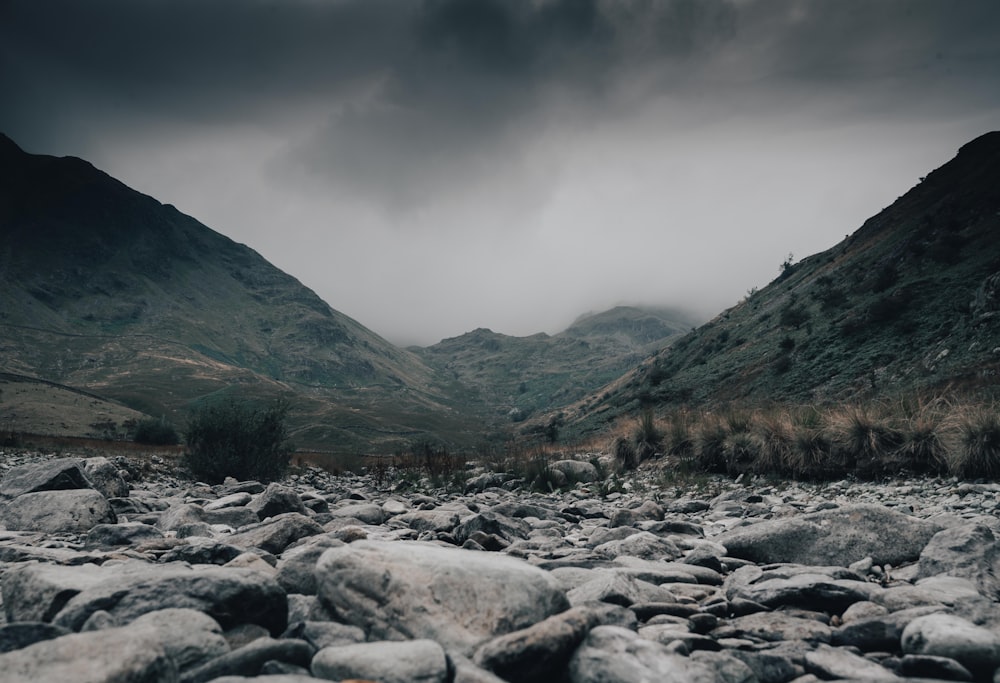 a rocky river bed with mountains in the background