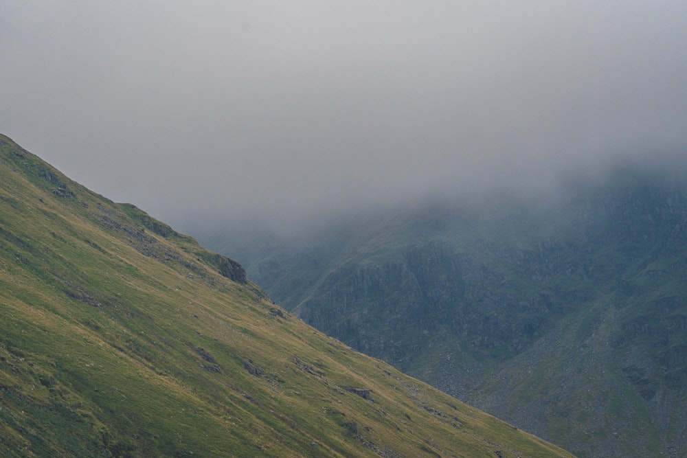 a lone sheep standing on the side of a mountain