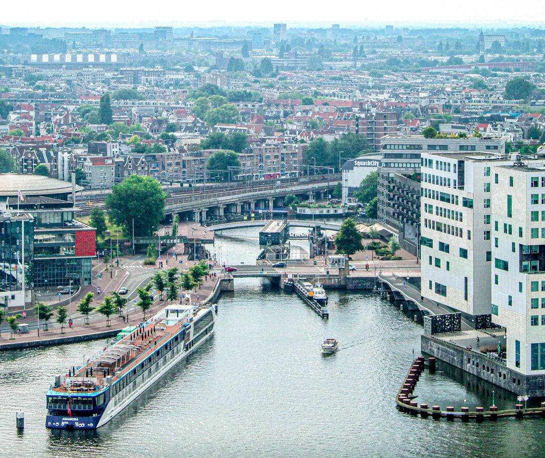 a river running through a city next to tall buildings, The Amsterdam
