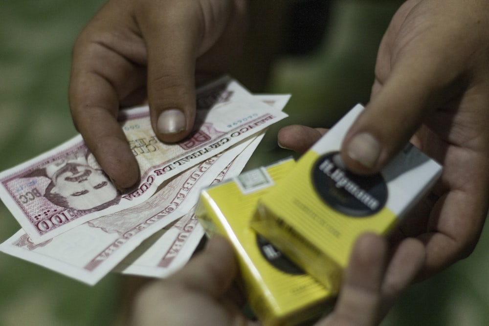 a person putting money into a yellow box