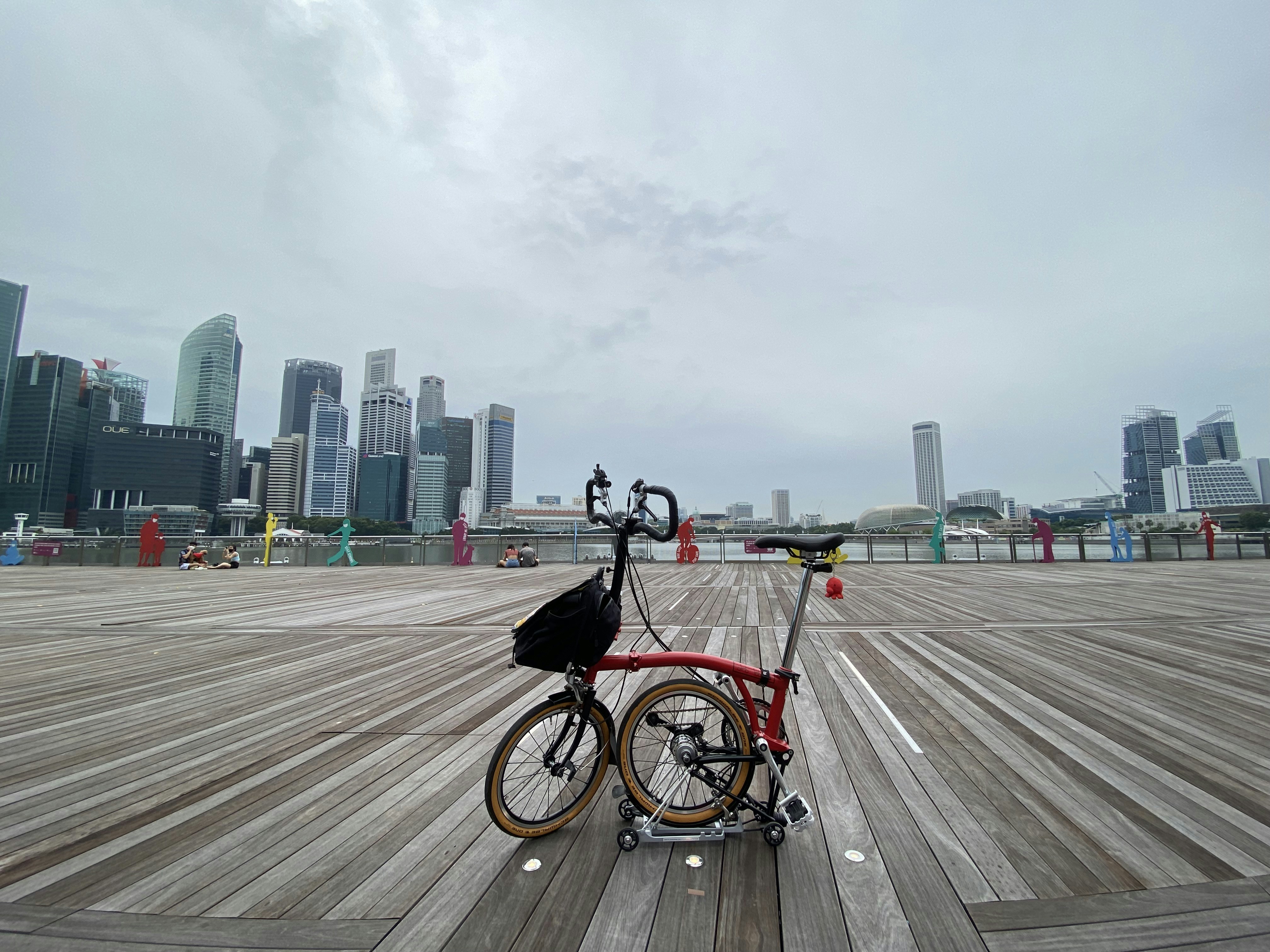 a bicycle is parked on a boardwalk in front of a city