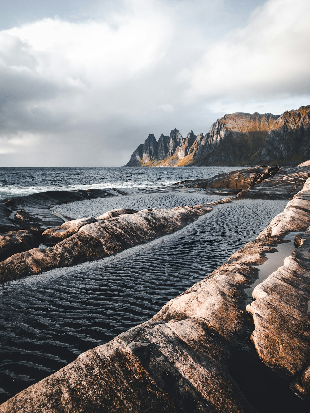 a large body of water sitting next to a rocky shore