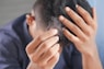 a man is combing his hair with his hands