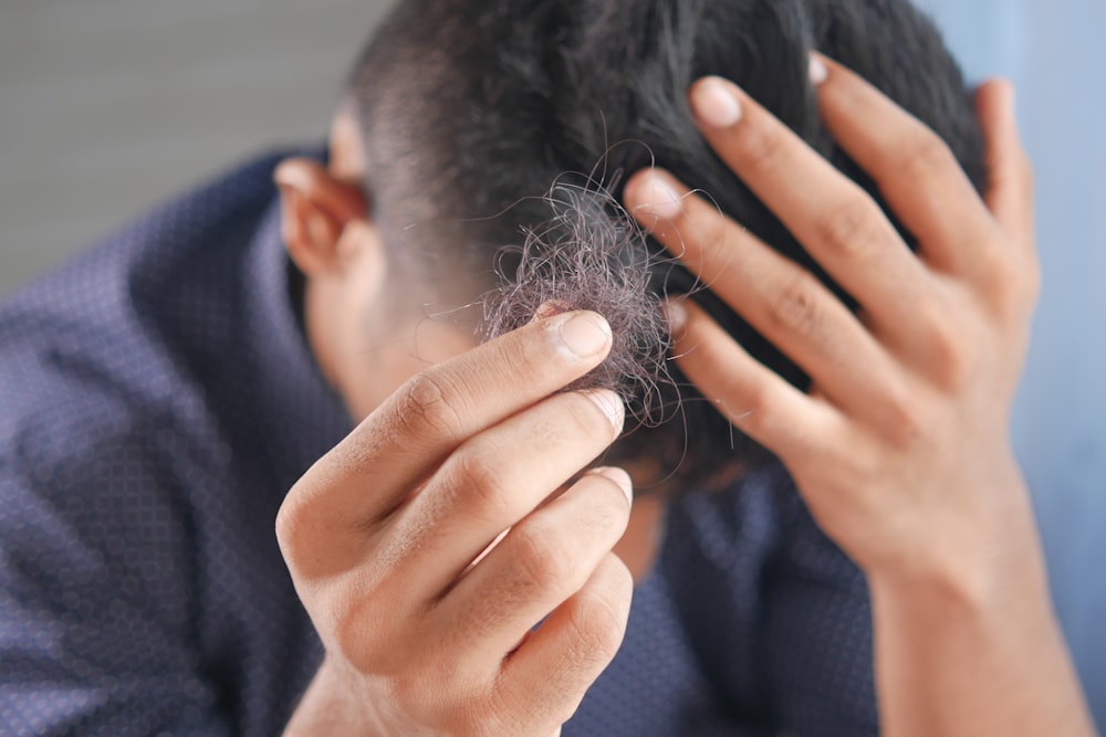 Ein Mann kämmt sich mit den Händen die Haare