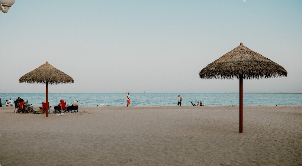 a group of people sitting on top of a sandy beach