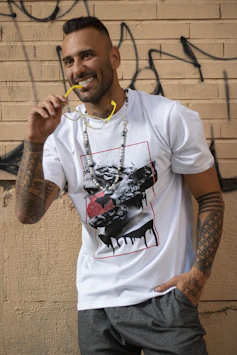 a man standing in front of a wall with a toothbrush in his mouth