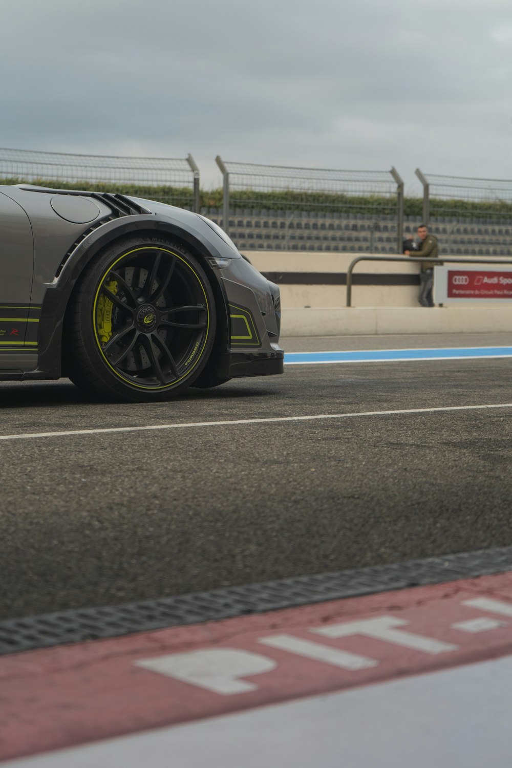 a grey sports car driving down a race track