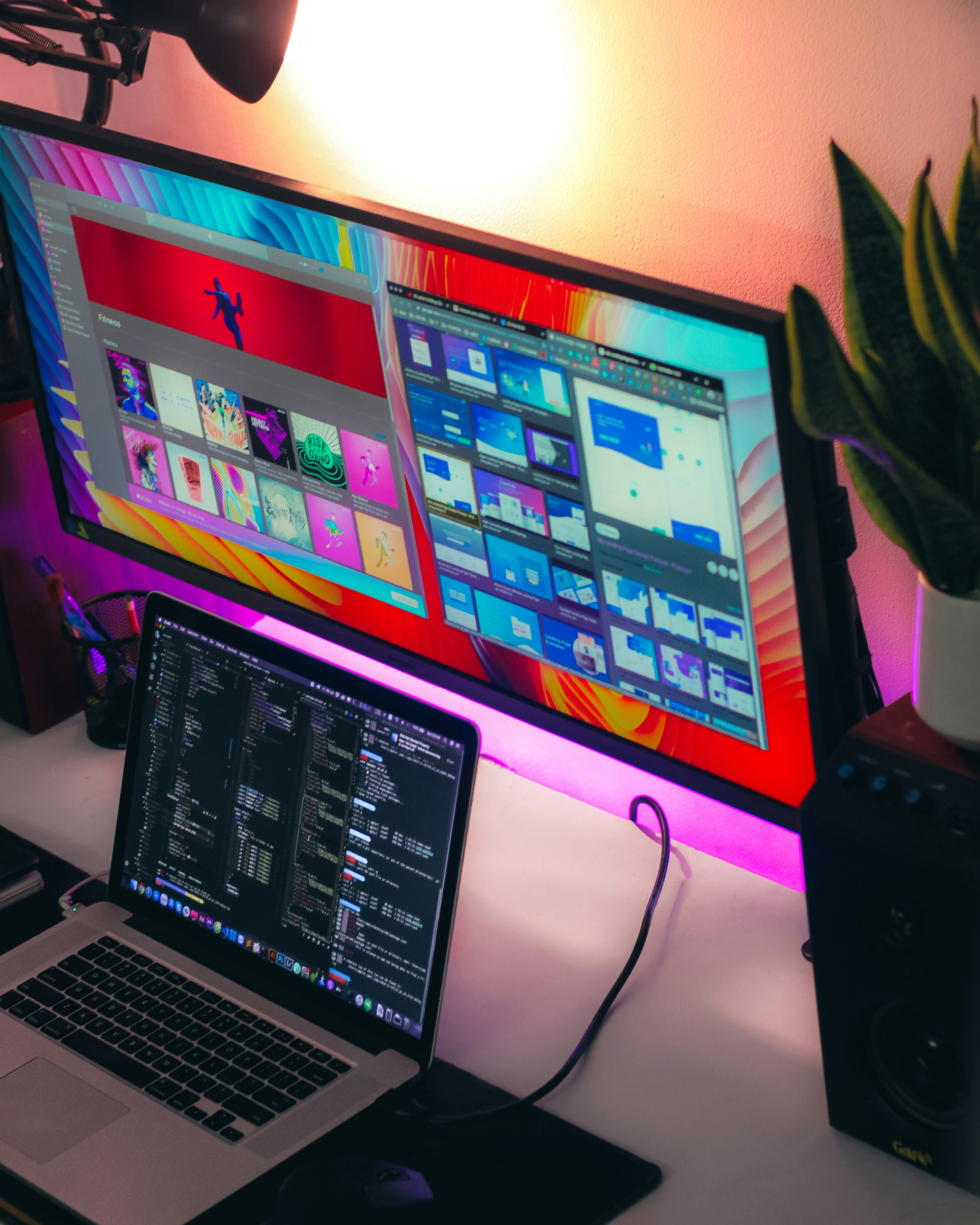 Web design project displayed on desktop monitor with dark interface and orange accent colors in bright office
