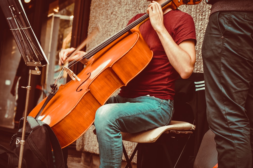 a man sitting on a chair playing a violin