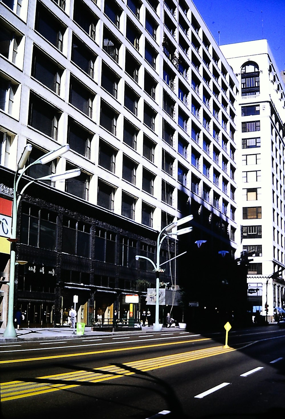 a city street lined with tall buildings next to a yellow traffic light