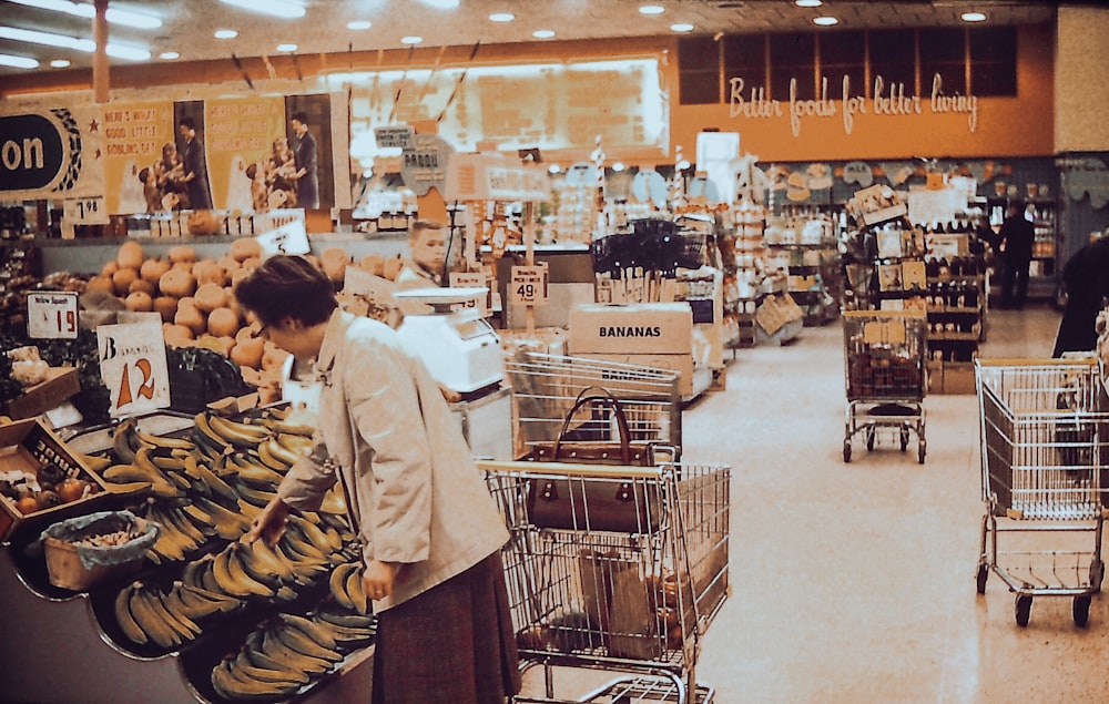 a woman is shopping in a store with bananas