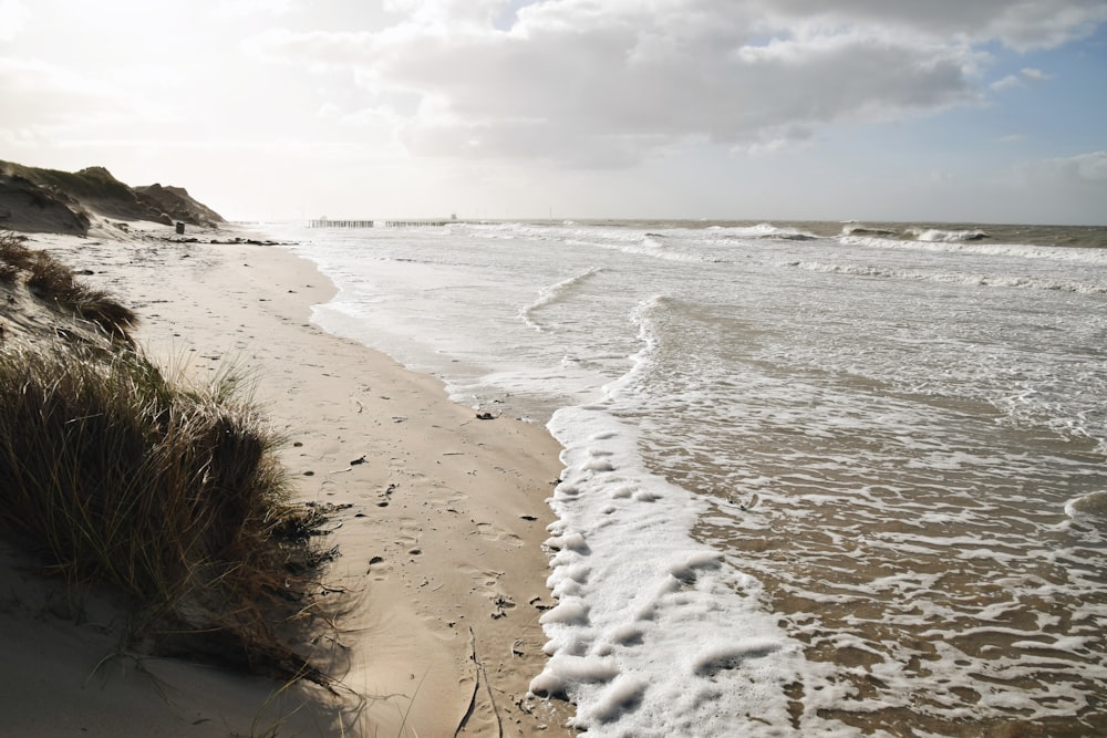 a sandy beach with waves coming in to shore