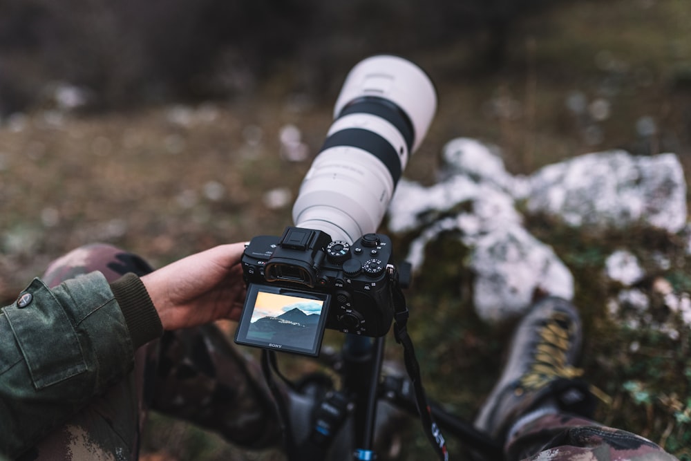 a person taking a picture of a mountain with a camera