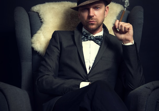 a man in a tuxedo smoking a cigarette