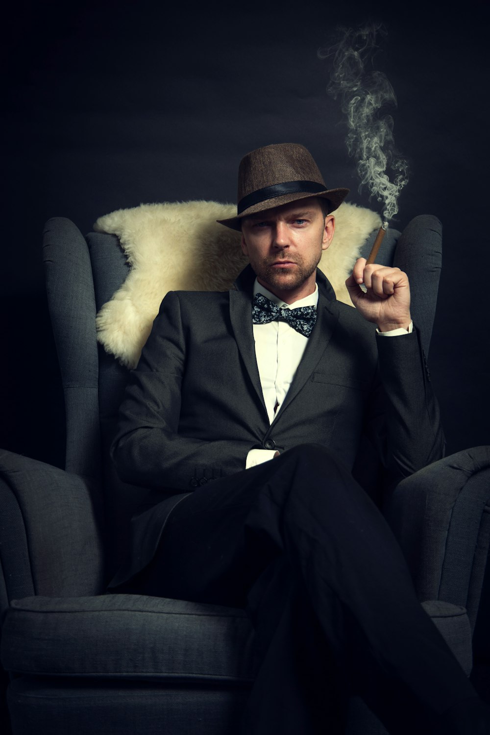 a man in a tuxedo smoking a cigarette